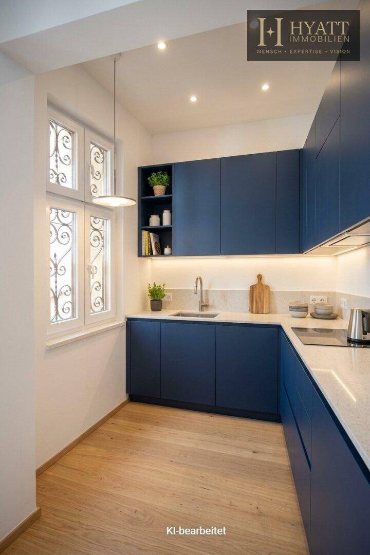 Moderne Küche mit dunkelblauen Schränken, heller Arbeitsplatte und Holzboden.