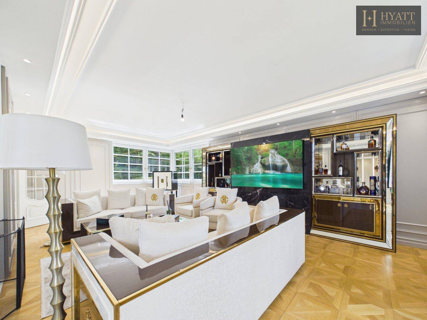 Stilvolles Wohnzimmer mit Parkettboden, großem Fernseher und luxuriöser Bar.