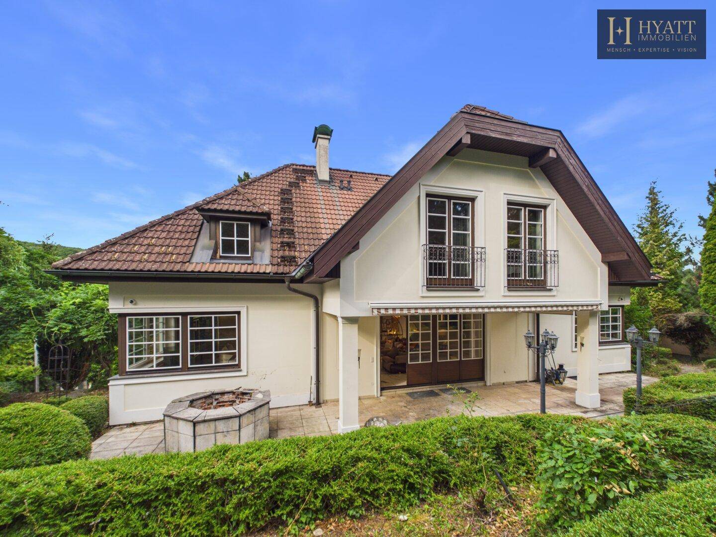 Traditionelles Haus mit Satteldach, Terrasse und gepflegtem Gartenbereich.