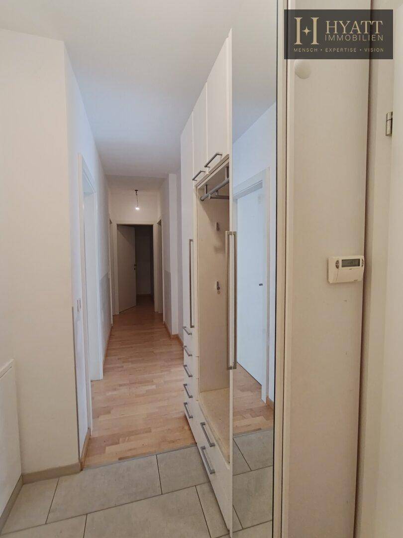 Eingangsbereich mit Fliesen- und Parkettboden, ausgestattet mit einem praktischen Spiegelschrank.