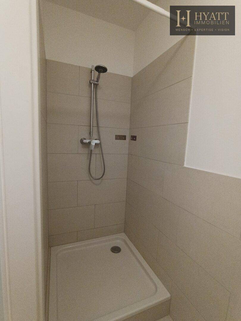 Separate Duschkabine mit Fliesenwänden und moderner Duscharmatur.