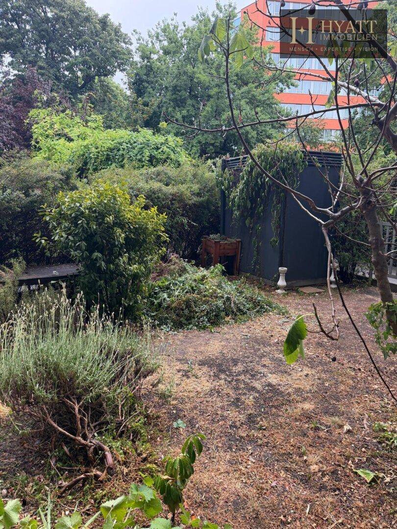 Wild bewachsener Garten mit verschiedenen Pflanzen und Bäumen, bietet viel Privatsphäre.
