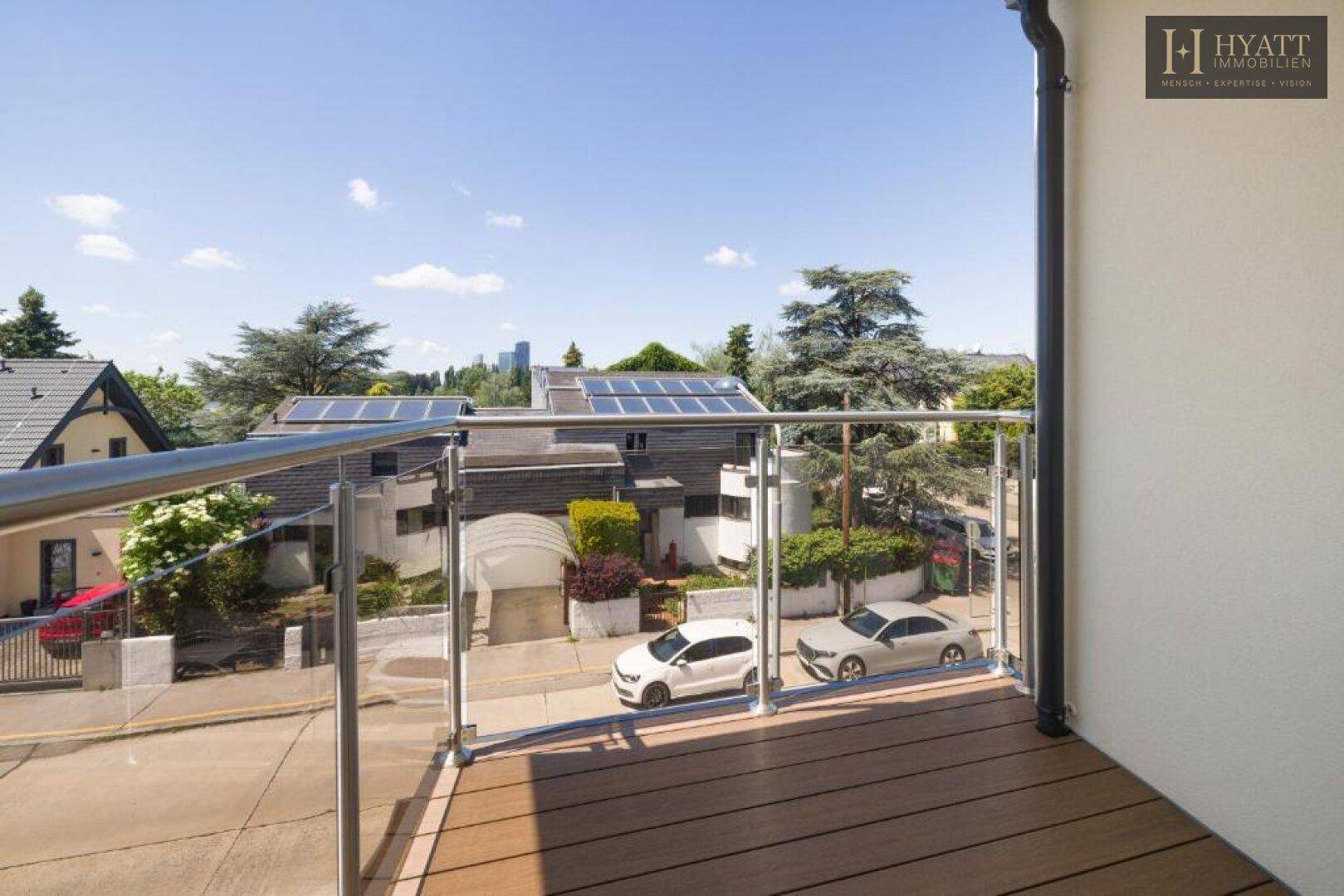 Balkon mit Glasgeländer bietet einen weiten Blick auf die Straße und die Umgebung.
