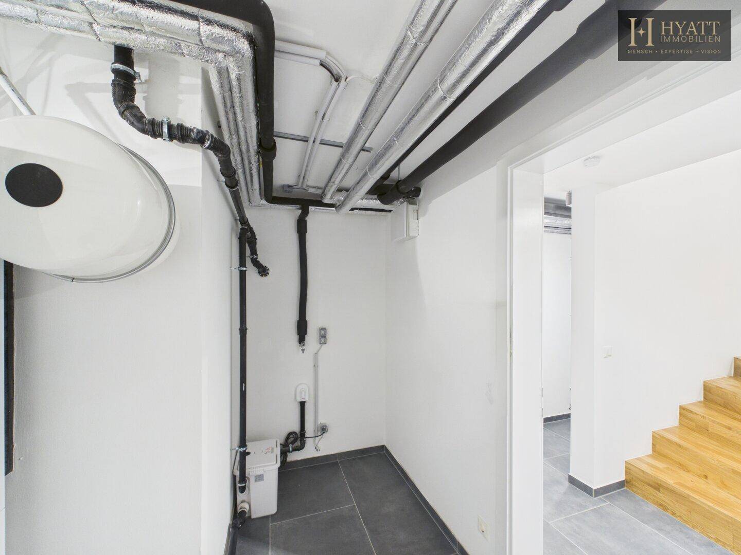 Kleiner Abstellraum im Keller mit sichtbaren Rohren an der Decke.