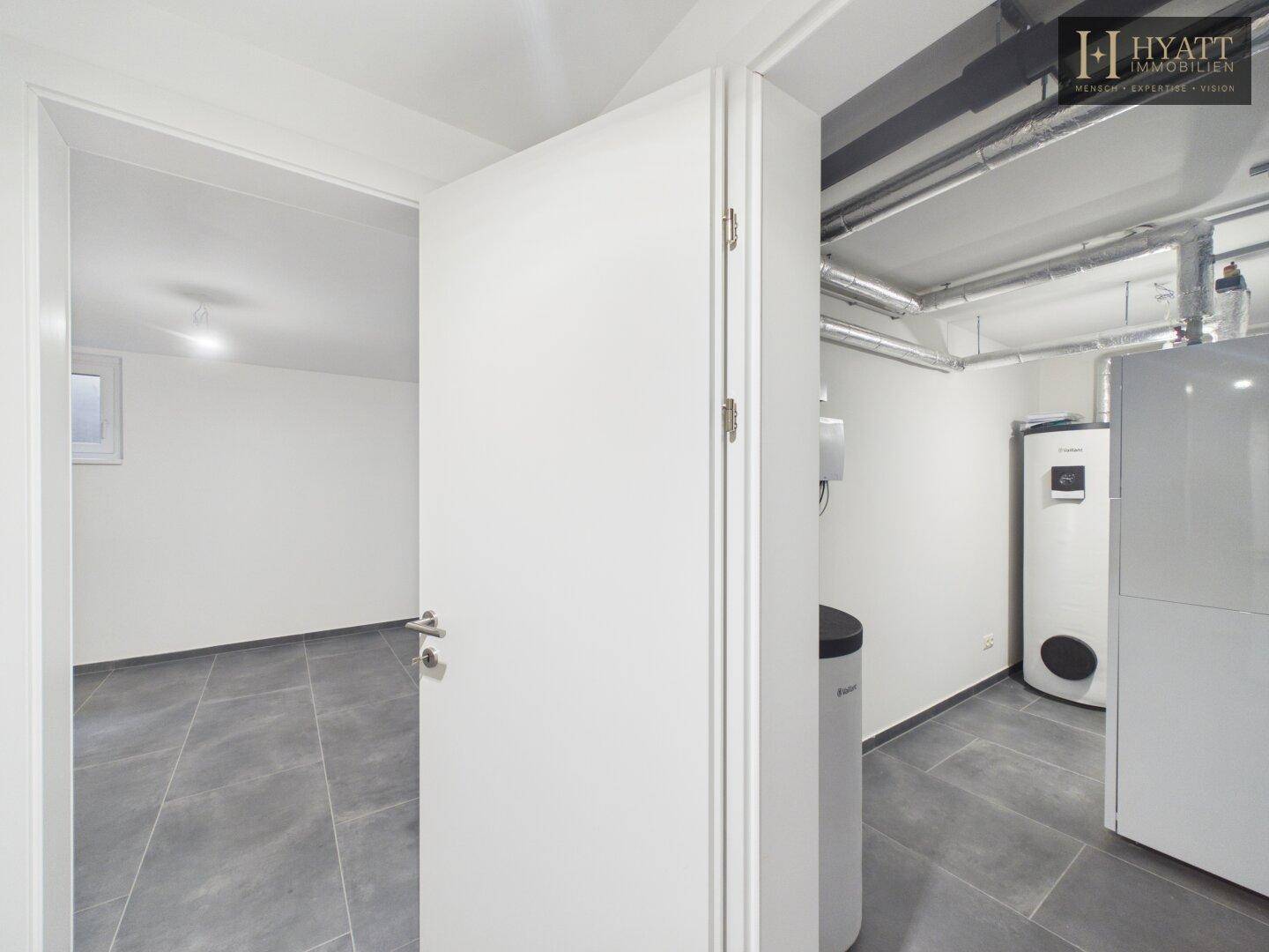 Hauswirtschaftsraum im Keller mit Heizungsanlage und sichtbaren Installationen.