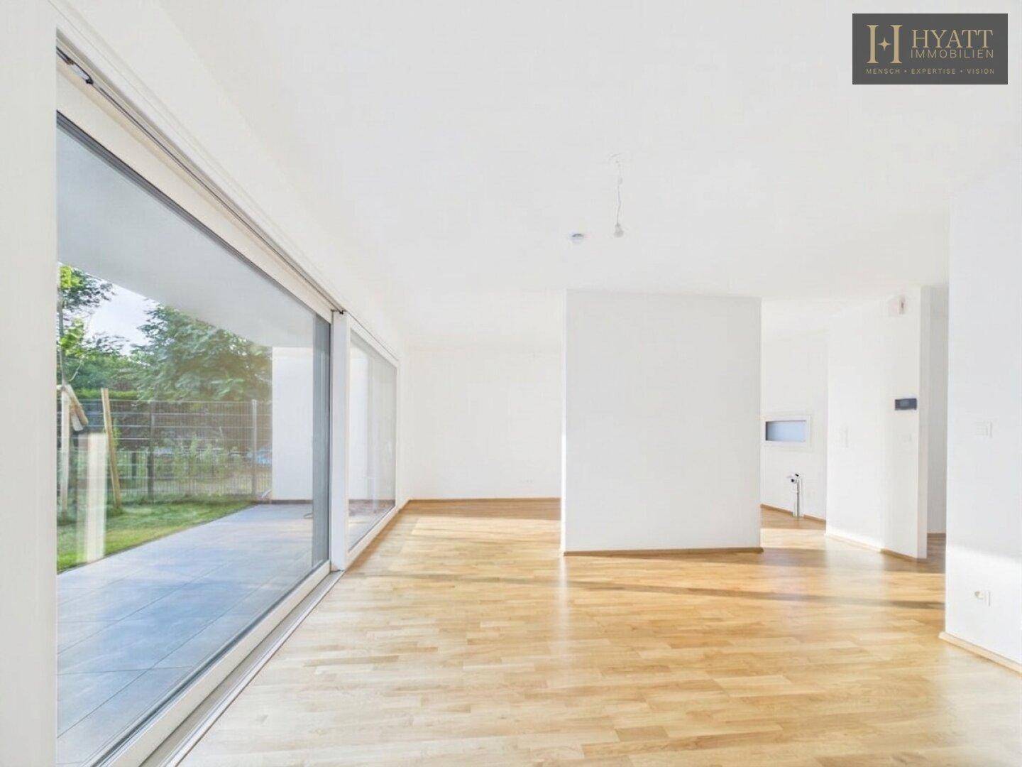 Lichtdurchfluteter Wohnraum mit Parkettboden und direktem Zugang zum Garten.