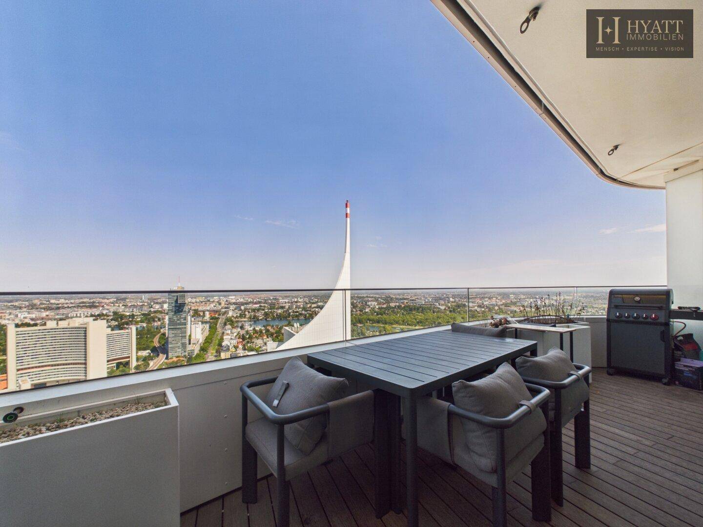 Großer Balkon mit Esstisch, Grill und beeindruckendem Panoramablick über die Stadt.