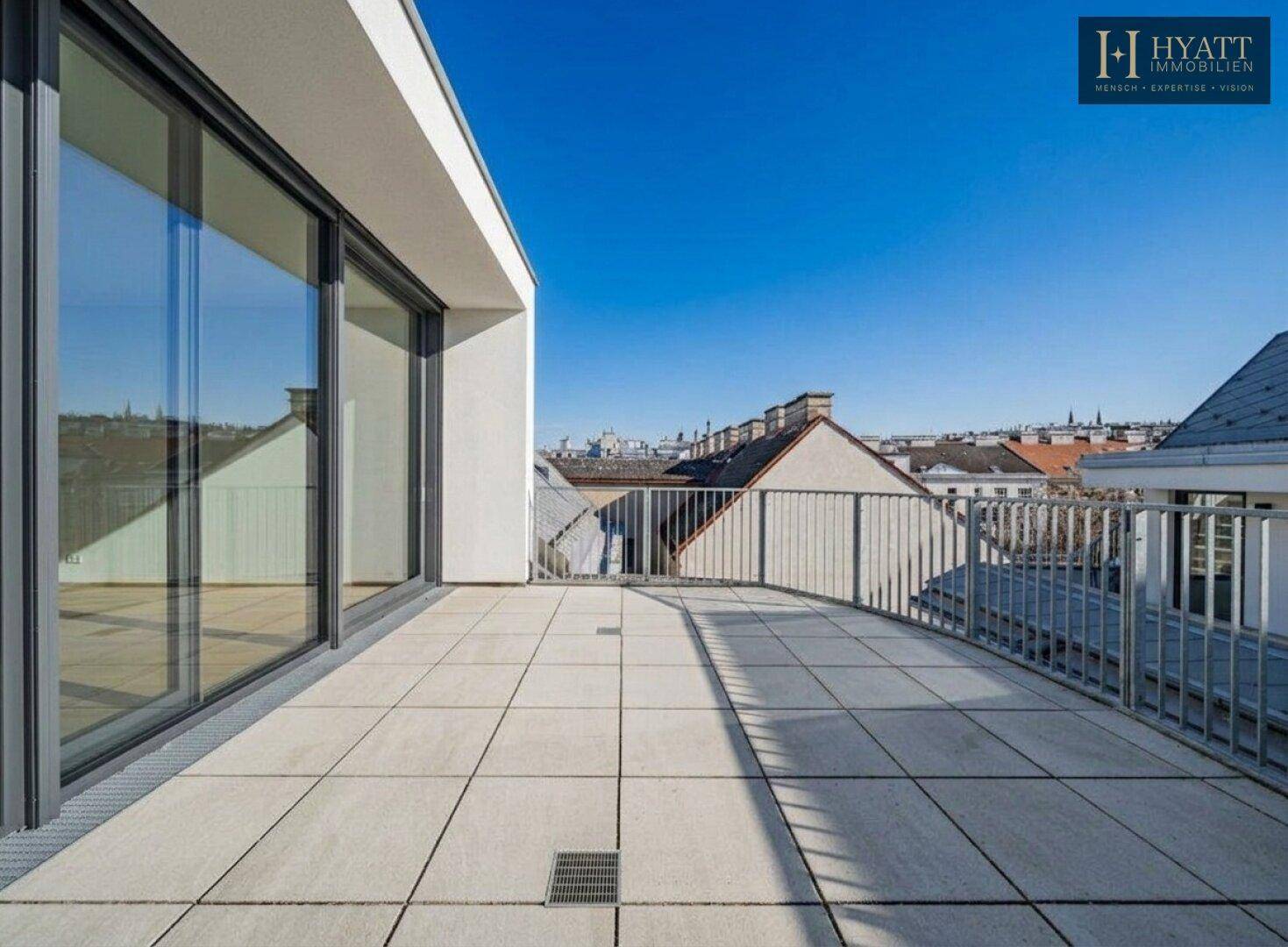 Geräumige Dachterrasse mit Fliesenboden und weitem Blick über die Dächer der Stadt.
