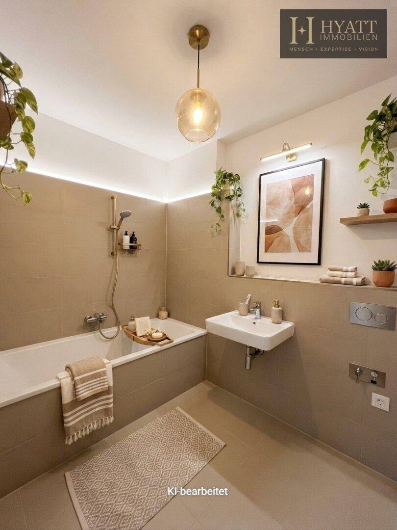 Modernes Badezimmer mit Badewanne, Waschbecken und WC, in hellen Beigetönen gehalten.