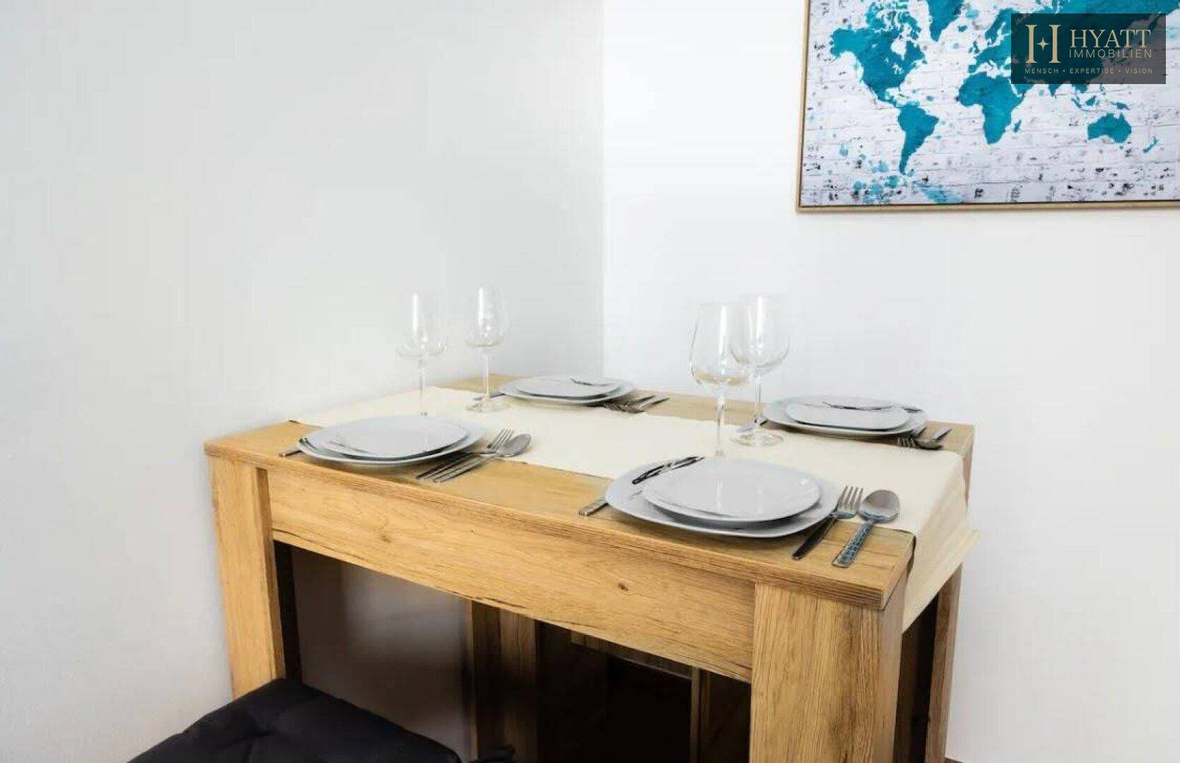 Kleiner Esstisch aus Holz, elegant gedeckt für zwei Personen, in einem hellen Wohnbereich.
