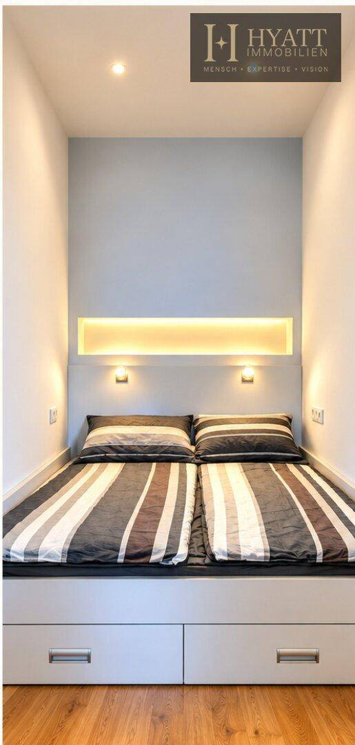 Kompaktes Schlafzimmer mit integriertem Bett und Stauraum, beleuchteter Nische und Holzboden.