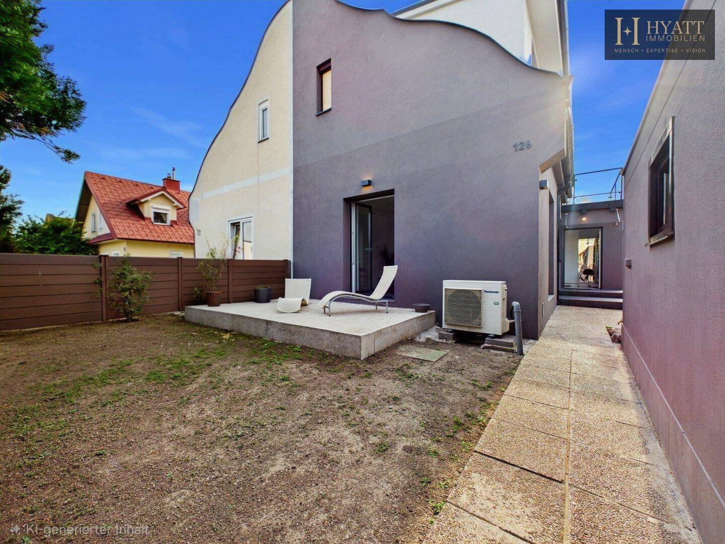 Hinterhof mit Rasenfläche, kleiner Terrasse und Klimaanlage an der modernen Hausfassade.