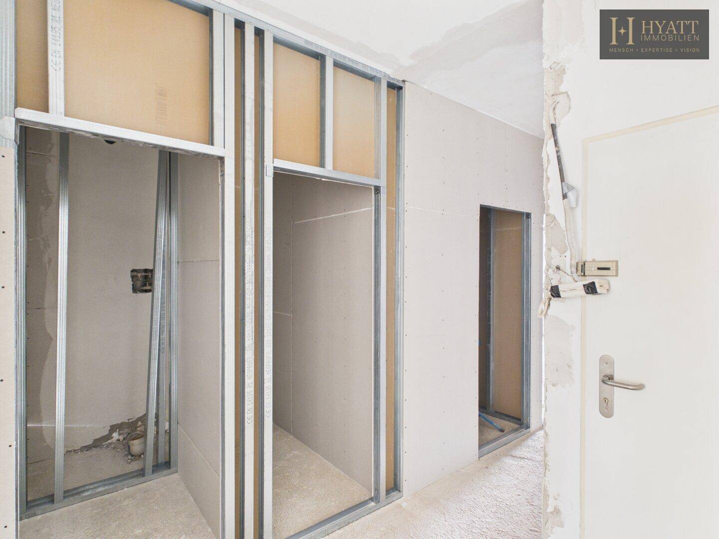 Innenraum im Rohbau mit Türöffnungen und Trockenbaukonstruktion für den weiteren Ausbau der Wohnung.