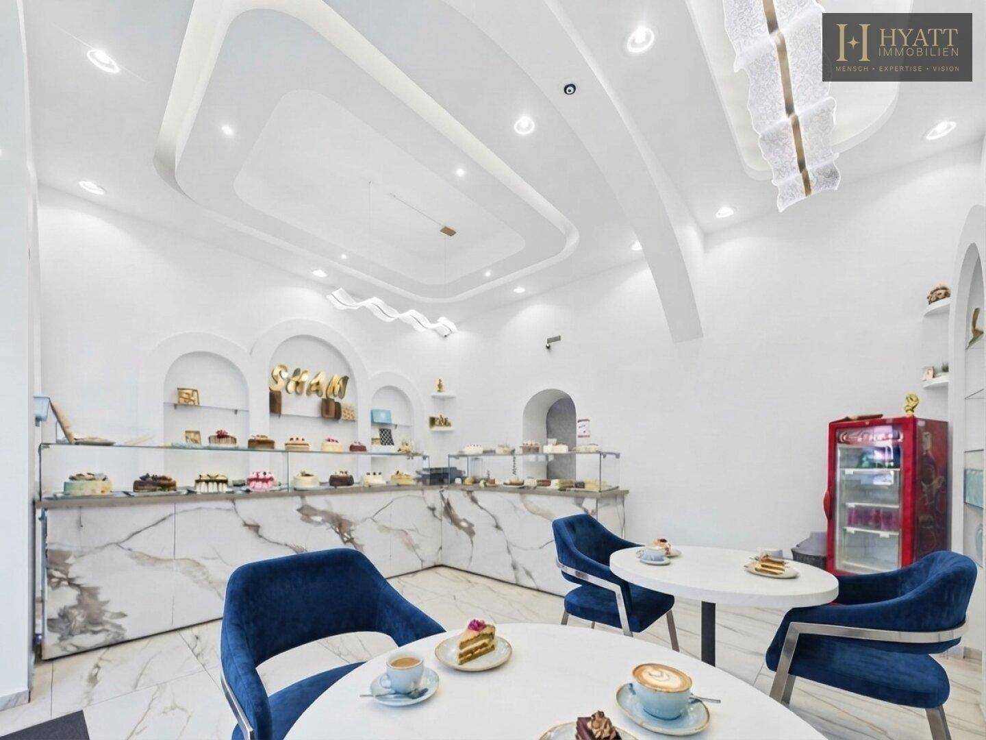Stilvoller Innenraum eines Cafés mit modernen Möbeln, Marmor-Look-Theken und dekorativer Beleuchtung.