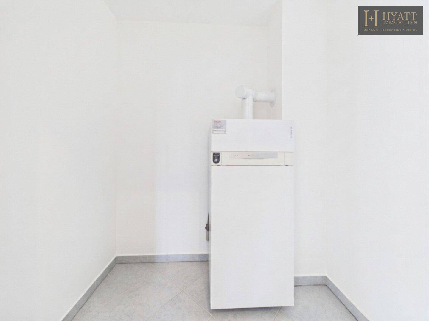 Praktischer Hauswirtschaftsraum mit Heizungsanlage und Fliesenboden.