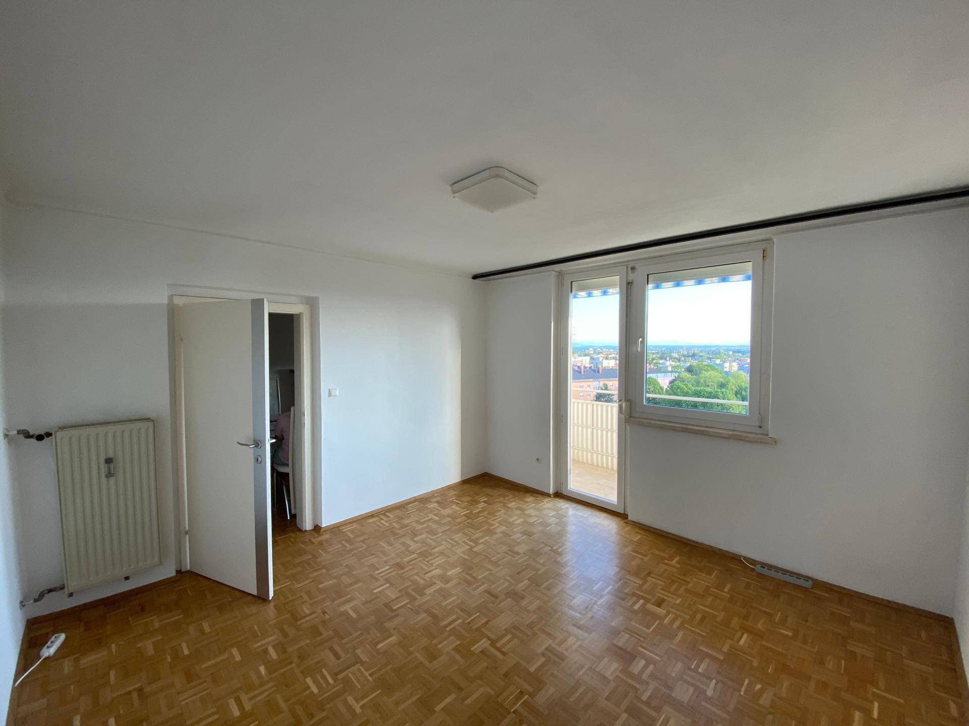Geräumiges Schlafzimmer mit Parkettboden und großen Fenstern für viel Tageslicht.