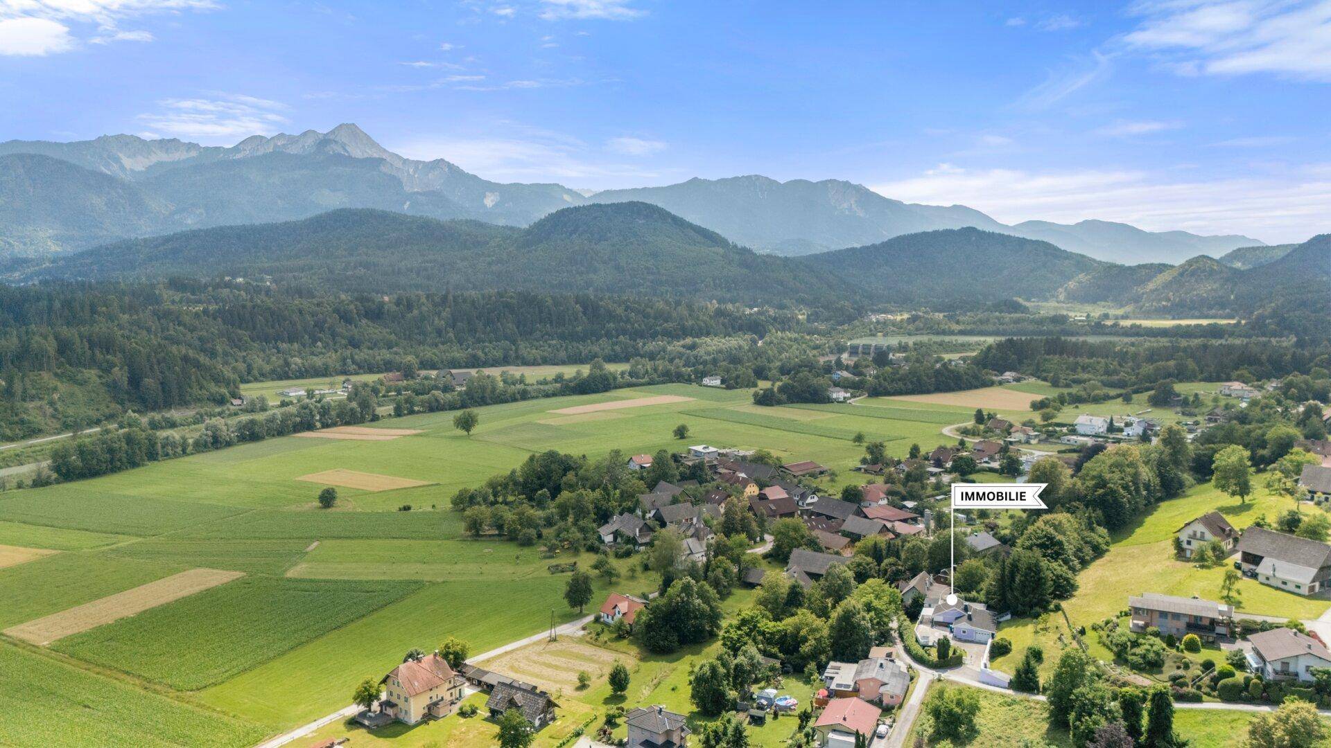 Luftaufnahme der Immobilie in einer ländlichen Umgebung mit Bergen im Hintergrund.