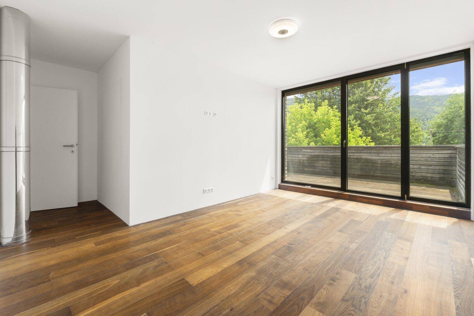 Geräumiges Zimmer mit Holzboden und Zugang zu einem Balkon mit Bergblick.