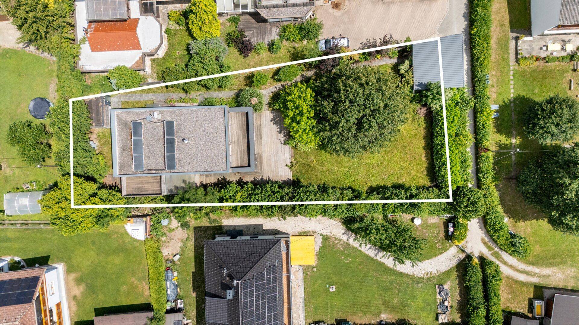 Luftaufnahme des Grundstücks mit Haus, Garten und Photovoltaikanlage auf dem Dach.