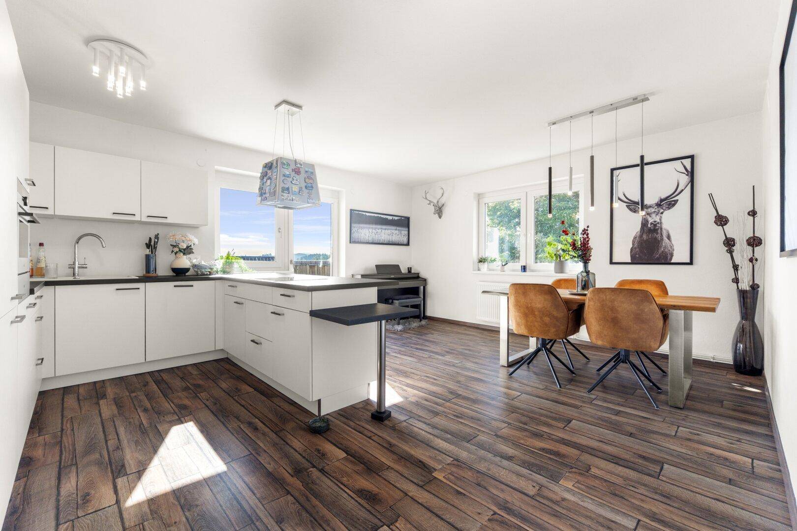 Offene Küche mit Essbereich, Holzboden und modernen Möbeln, ideal für geselliges Beisammensein.