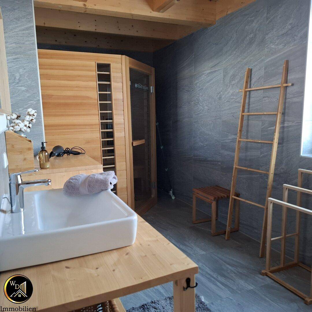 Modernes Badezimmer mit Sauna, Einzelwaschbecken und großformatigen Fliesen.