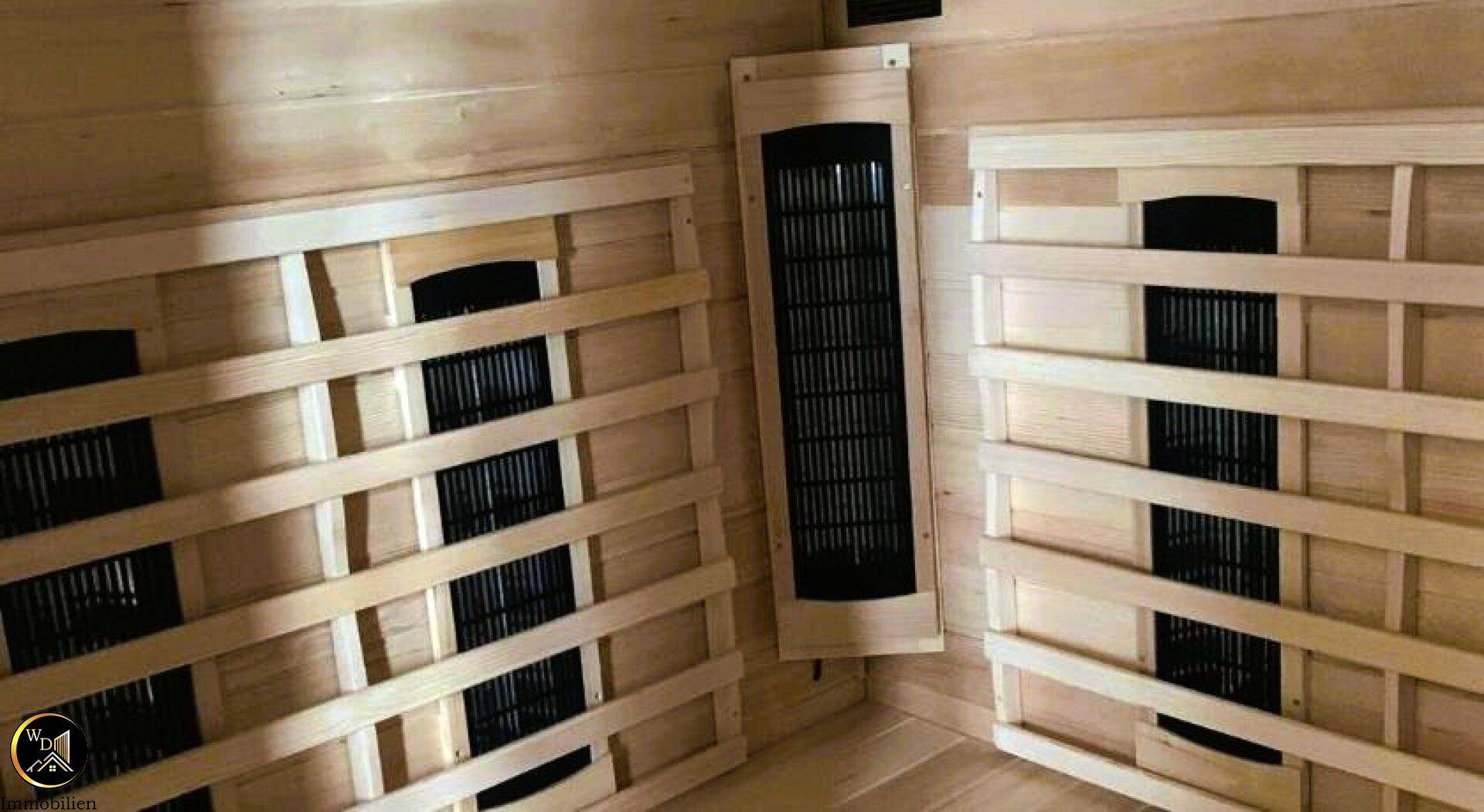 Innenansicht der Holzsauna mit Infrarotstrahlern für entspannende Wellnessmomente.