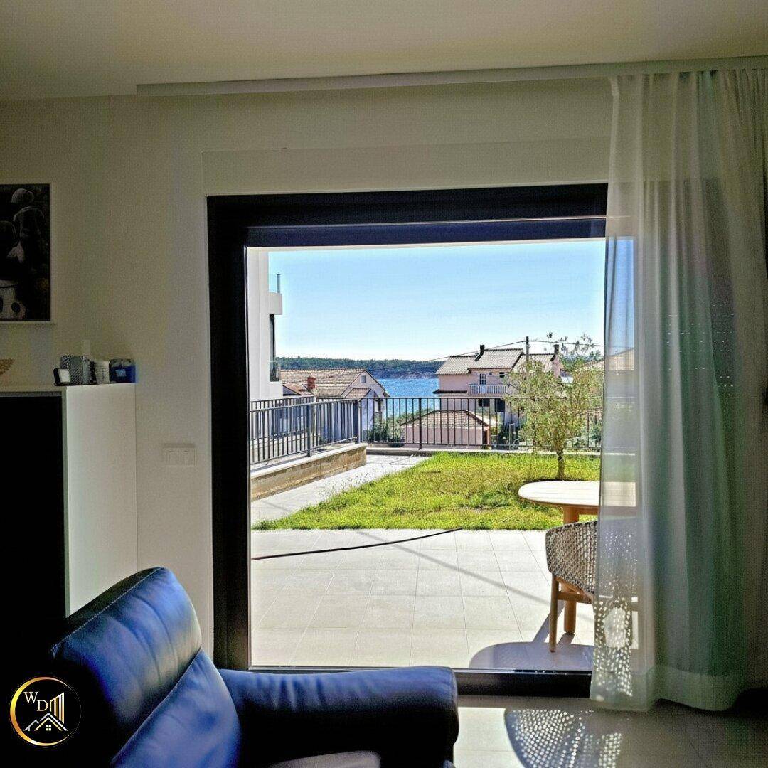 Heller Wohnbereich mit großen Fenstern, die einen weiten Blick auf das Meer und die Umgebung bieten.