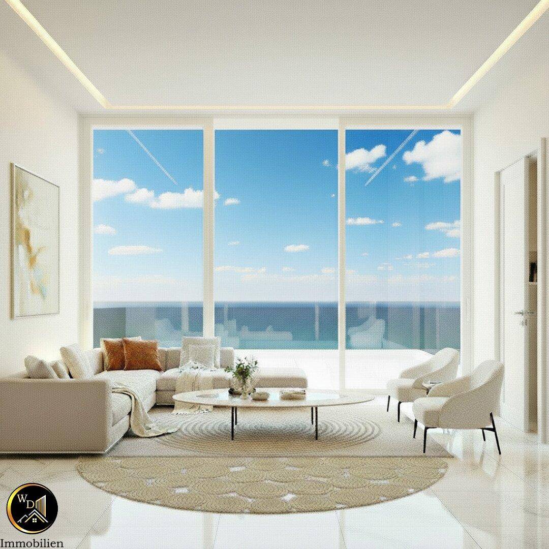 Helles Wohnzimmer mit Meerblick, modernen Möbeln und großen Fensterfronten.