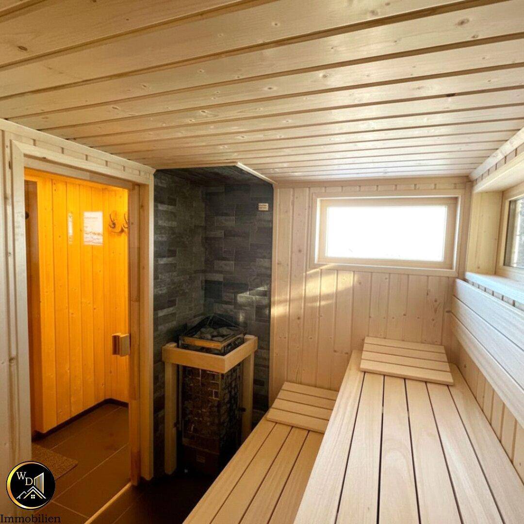 Gemütliche Holzsauna mit Bänken und Saunaofen, ideal zur Entspannung nach einem langen Tag.