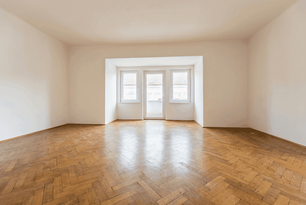 Geräumiges Zimmer mit glänzendem Fischgrätparkett und einem großen Fensterbereich für viel Licht.