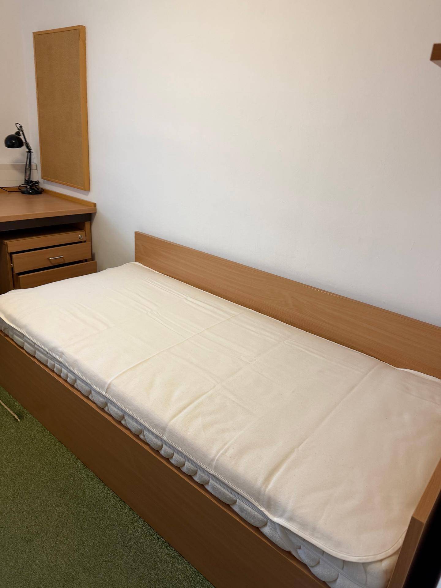 Nahaufnahme des Einzelbetts und des Schreibtischbereichs im Schlafzimmer.