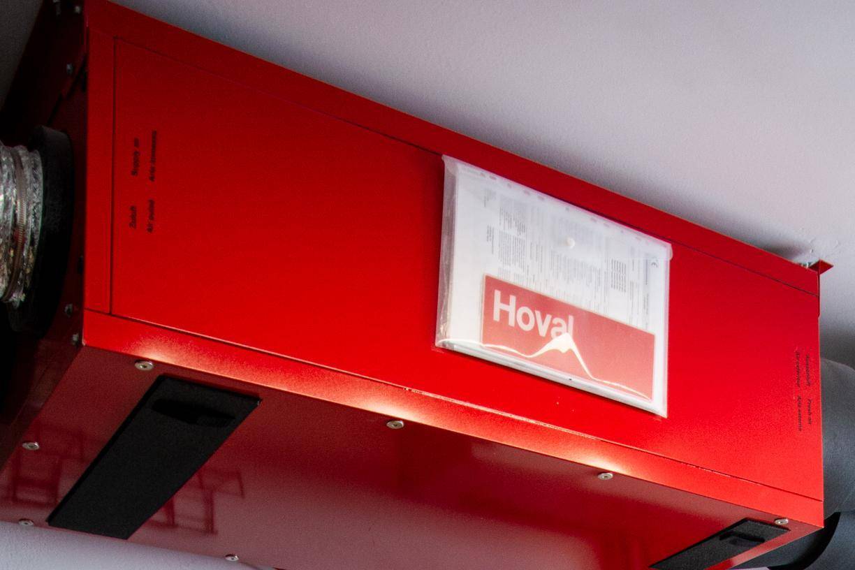 Rotes Lüftungsgerät von Hoval an der Decke montiert, Teil der Haustechnik.