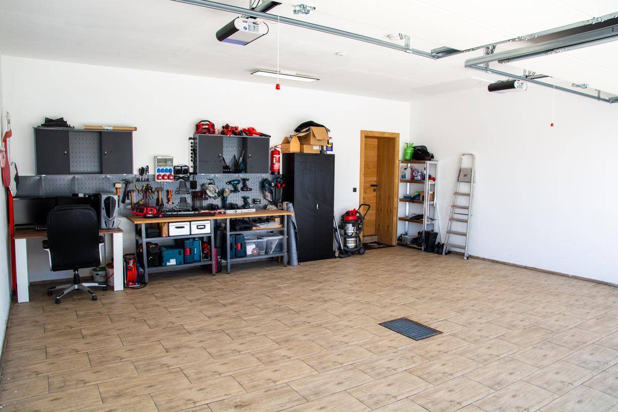Geräumige Garage mit Werkbank, Werkzeugen und viel Stauraum.