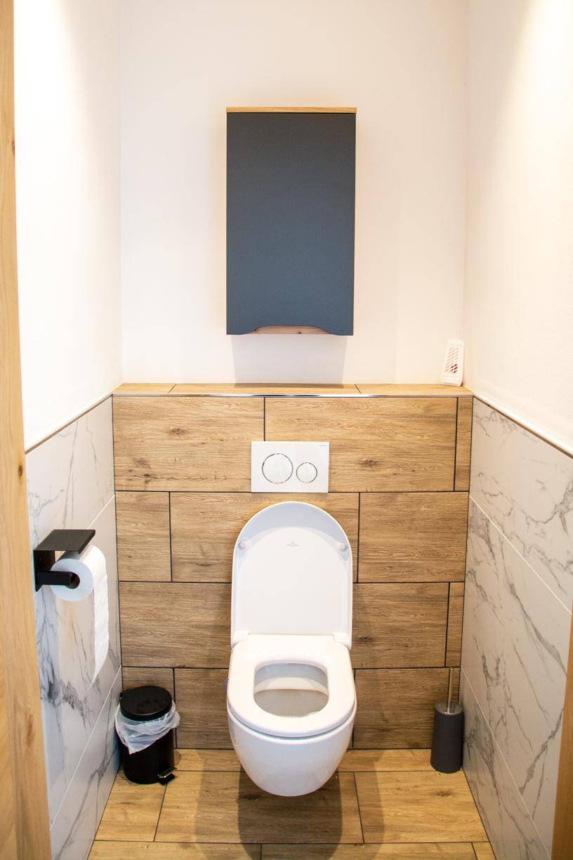 Sauberes Gäste-WC mit moderner Toilette und stilvoller Wandgestaltung.