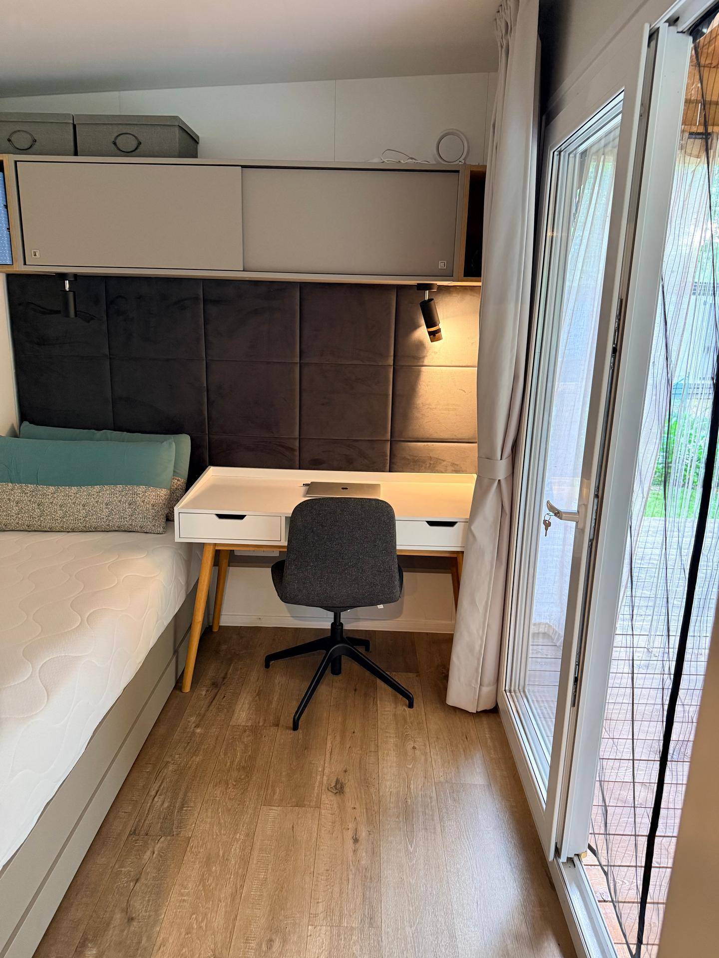 Schlafzimmer mit integriertem Arbeitsbereich, Schreibtisch und direktem Zugang zur Terrasse.