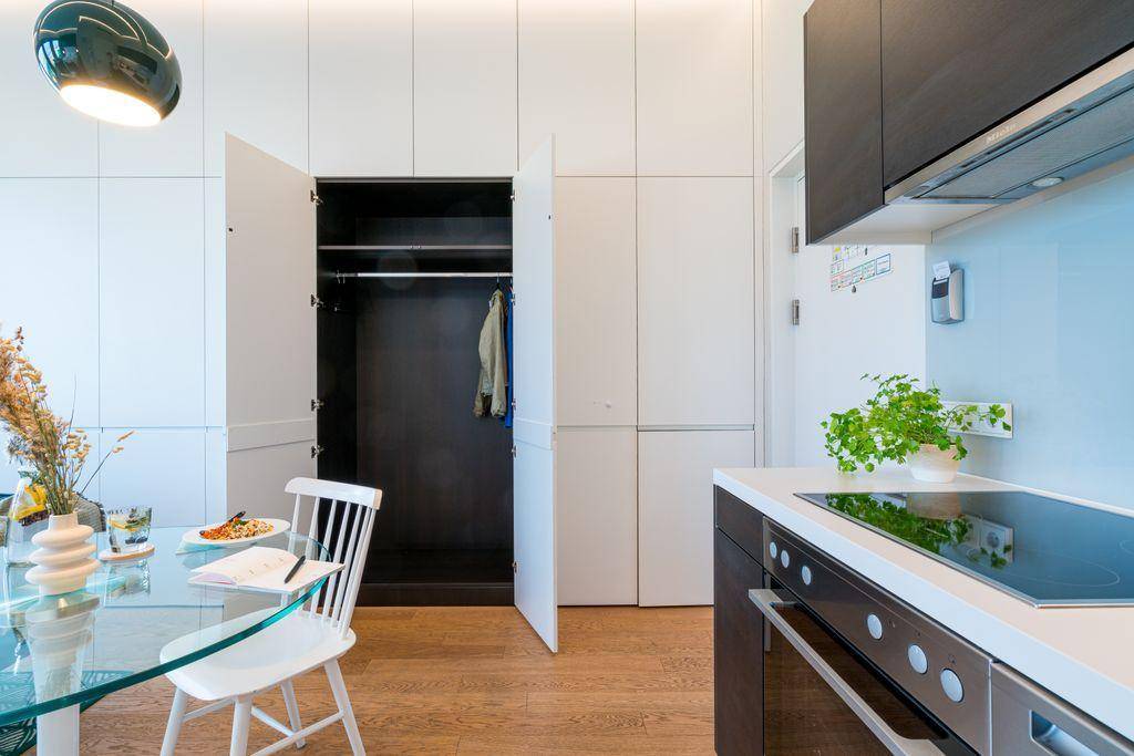 Moderne Küche mit Essbereich und integriertem Kleiderschrank in einem offenen Wohnkonzept.