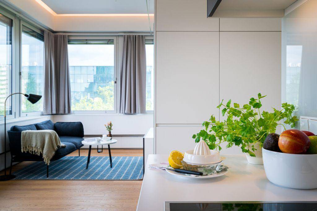 Moderne Küchenzeile mit weißer Arbeitsplatte und Blick auf den angrenzenden Wohnbereich.