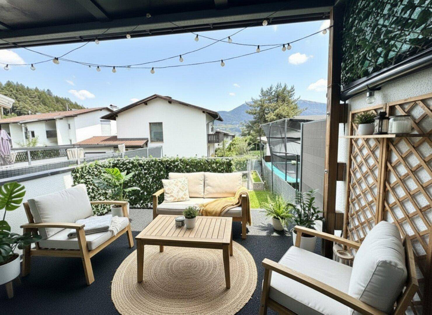 Gemütlicher Balkon mit Sitzgelegenheiten, Pflanzen und Blick auf die umliegende Landschaft und einen Pool.