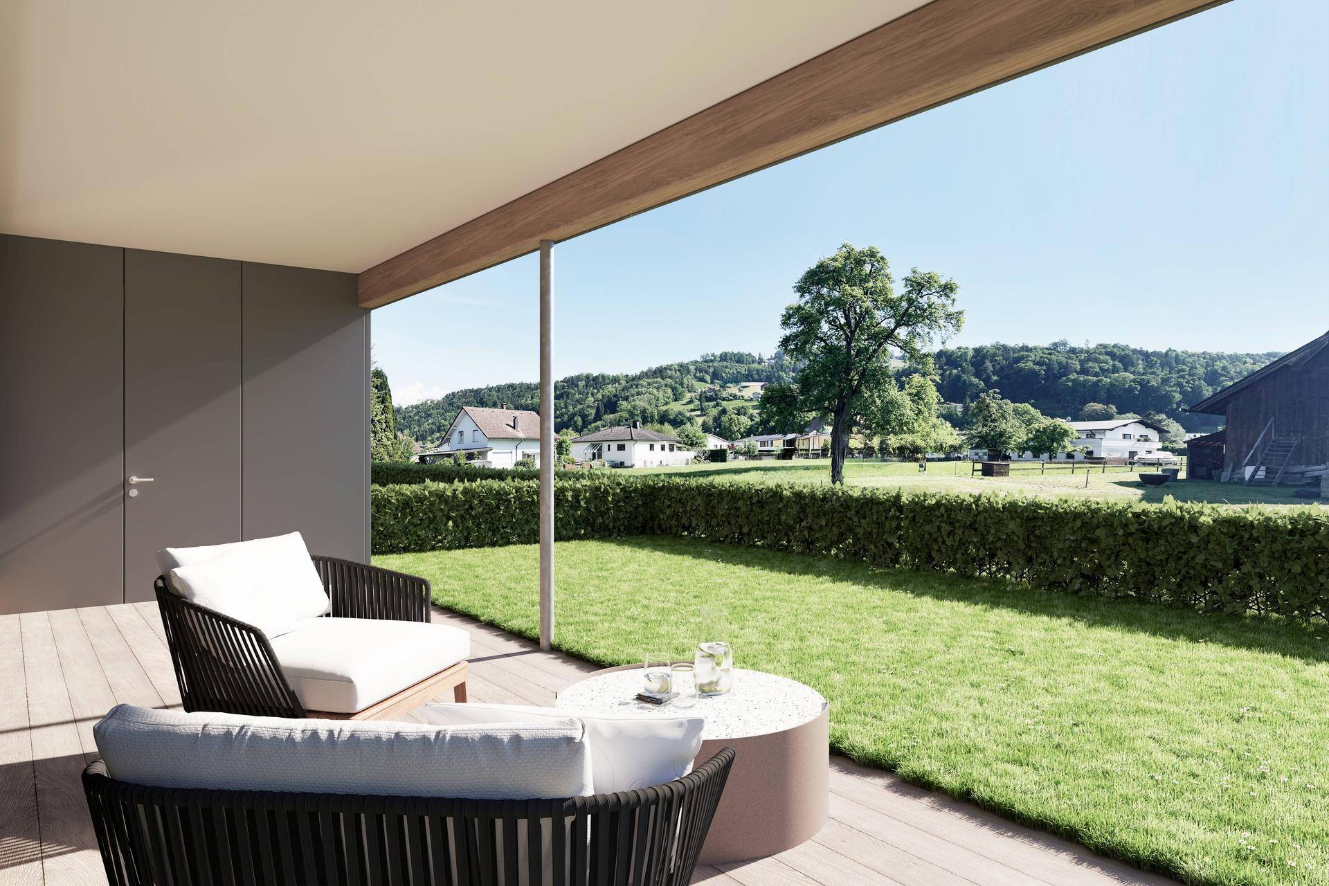 Überdachte Terrasse mit bequemen Loungemöbeln und weitem Blick über die grüne Landschaft.