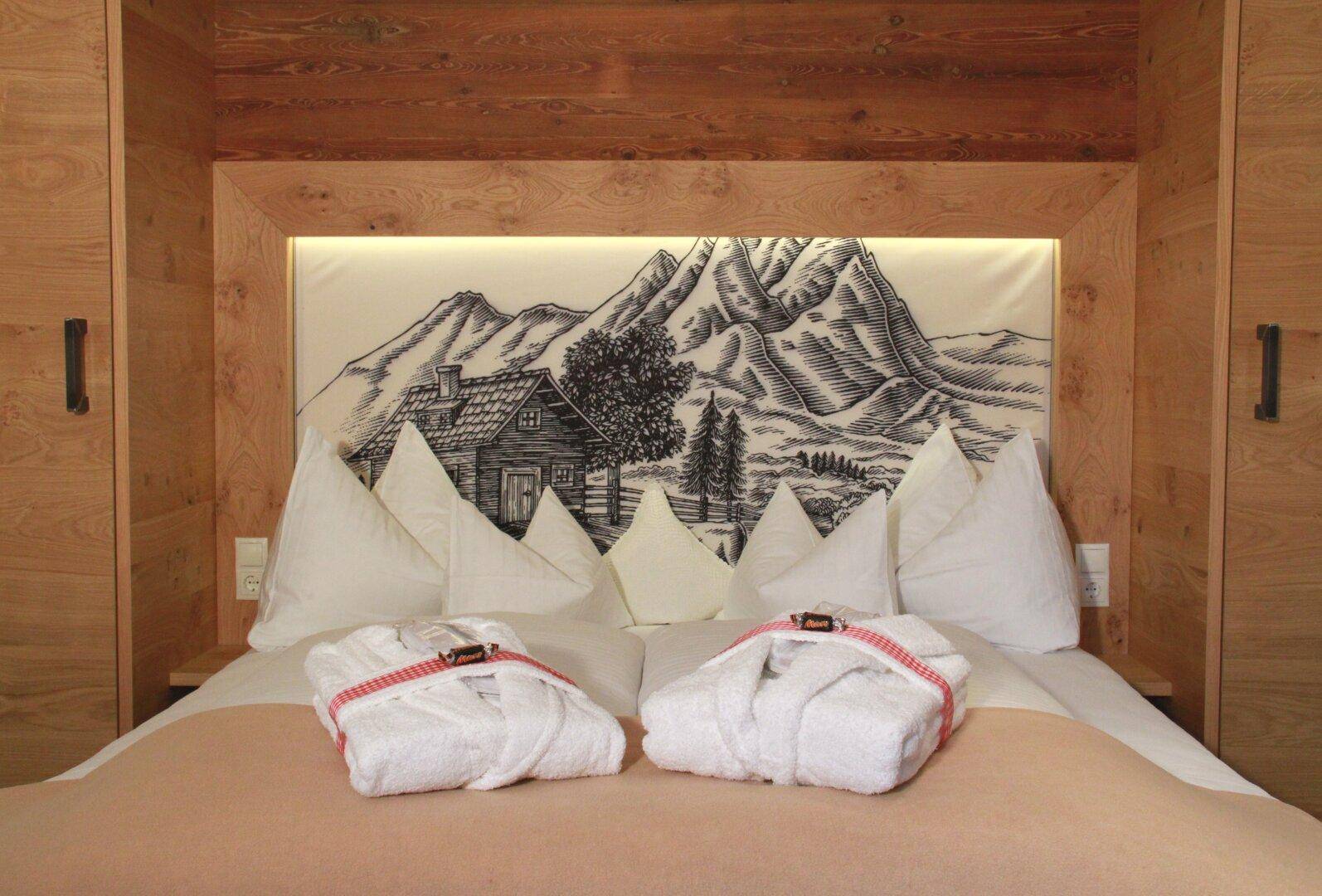 Schlafzimmer mit großem Bett, Holzkopfteil und Berglandschaftszeichnung.