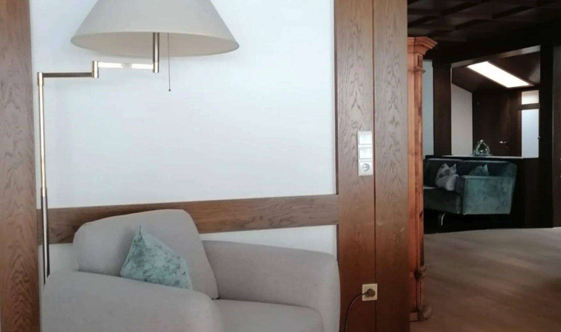 Gemütlicher Flurbereich mit bequemen Sesseln, Stehlampe und Holzelementen.