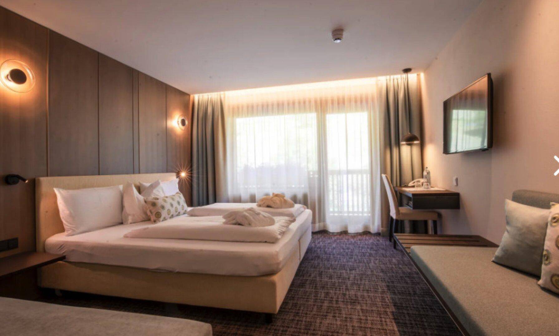 Komfortables Schlafzimmer mit Doppelbett, Teppichboden und Zugang zu einem Balkon.