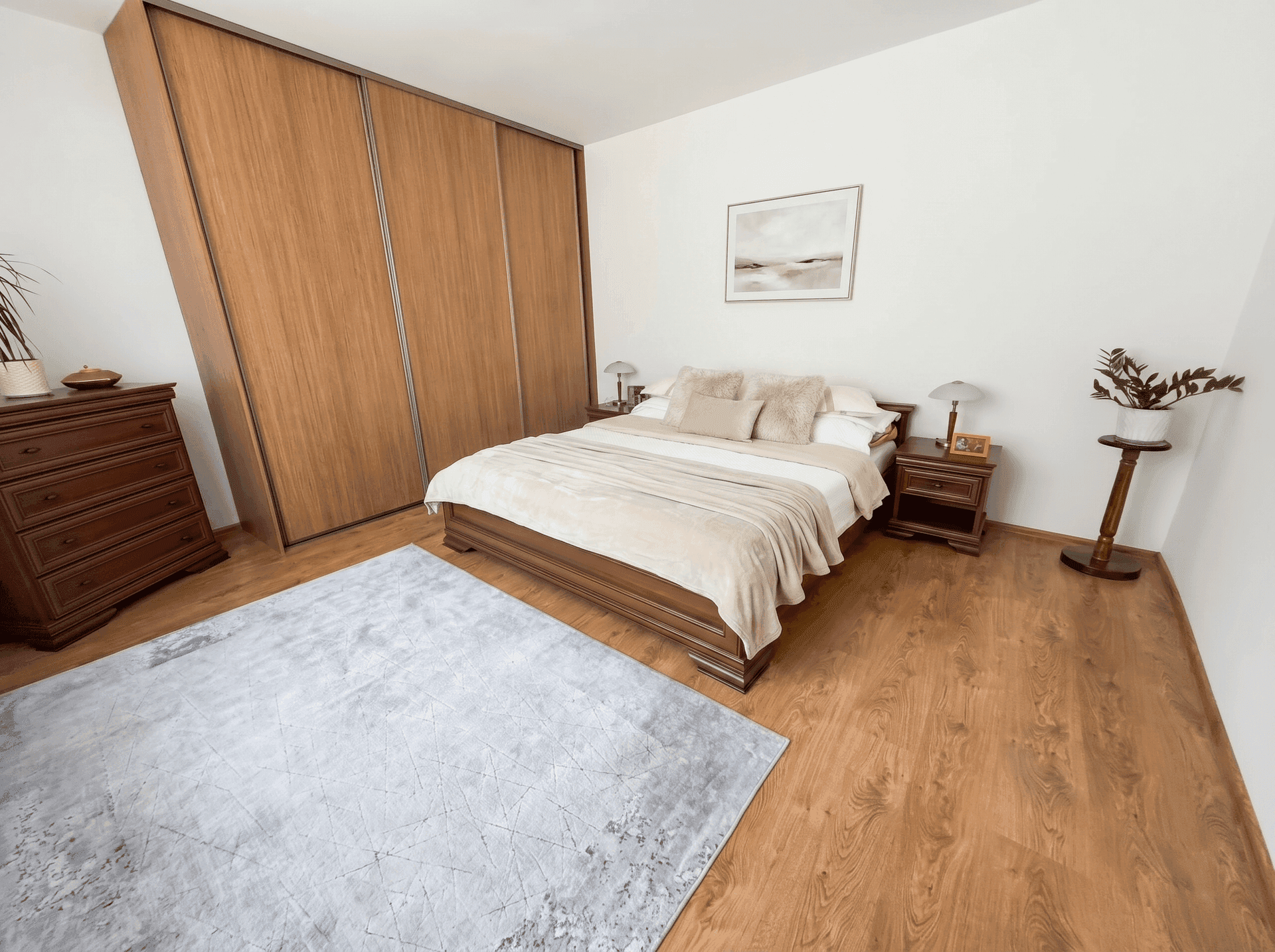 Gemütliches Schlafzimmer mit Holzboden, großem Bett und Einbauschränken.