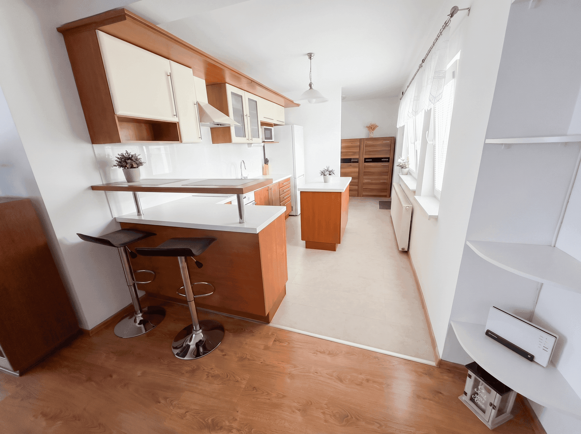 Offene Küche mit Frühstücksbar, Holzfronten und Verbindung zum Wohnbereich.