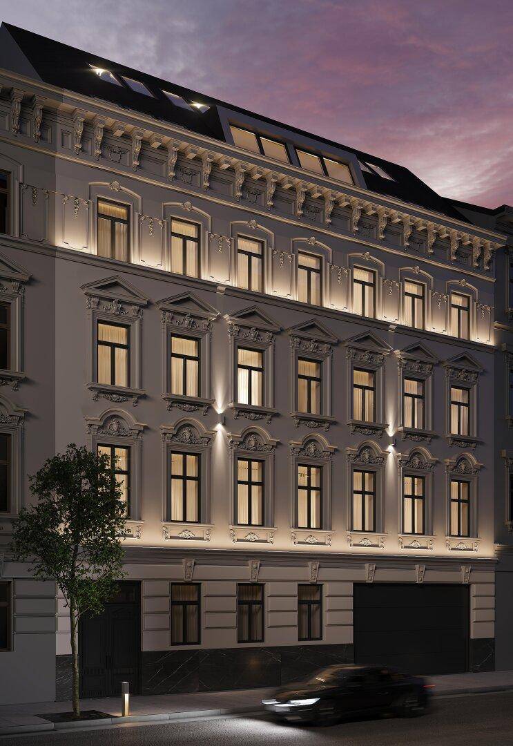 Historische Gebäudefassade bei Nacht mit stimmungsvoller Beleuchtung und vielen Fenstern.