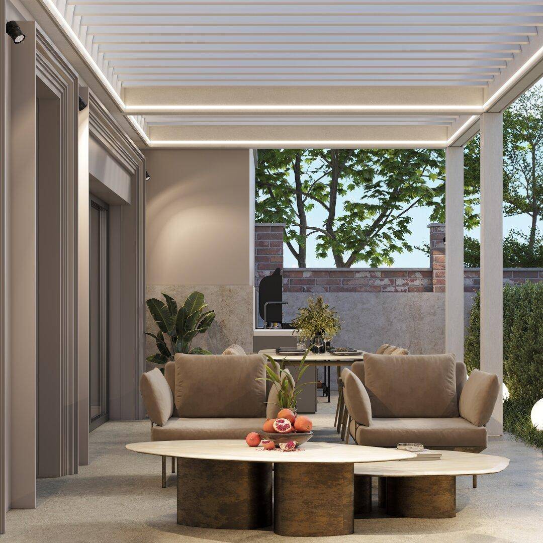 Gemütlicher Loungebereich auf der Terrasse unter einer modernen Pergola mit Blick ins Grüne.