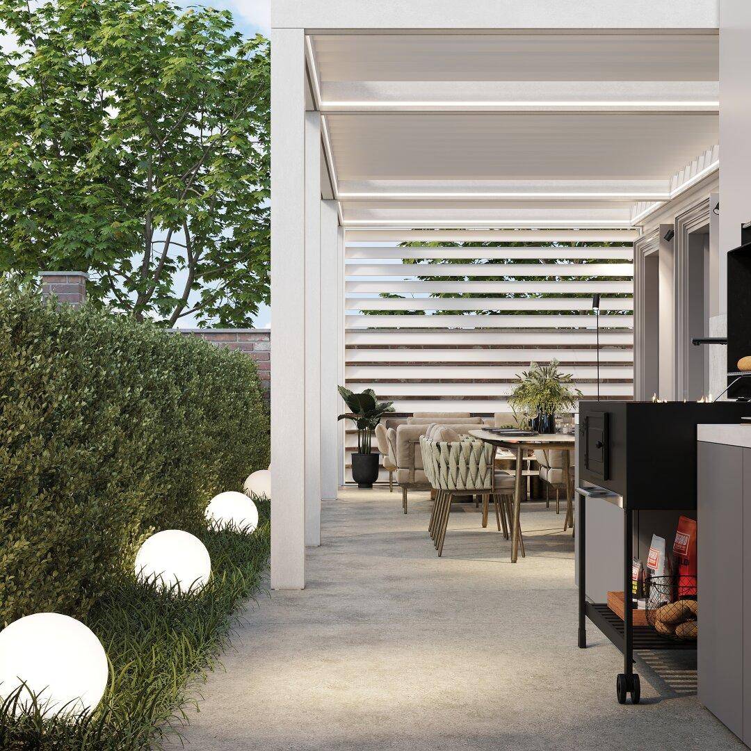 Weitläufige Terrasse mit Hecke, Gartenbeleuchtung und Essbereich im Freien.