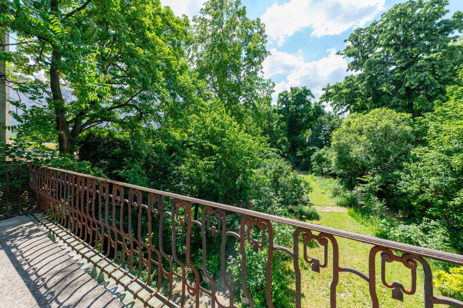 Balkon mit schmiedeeisernem Geländer und weitem Blick auf die umliegende grüne Landschaft.