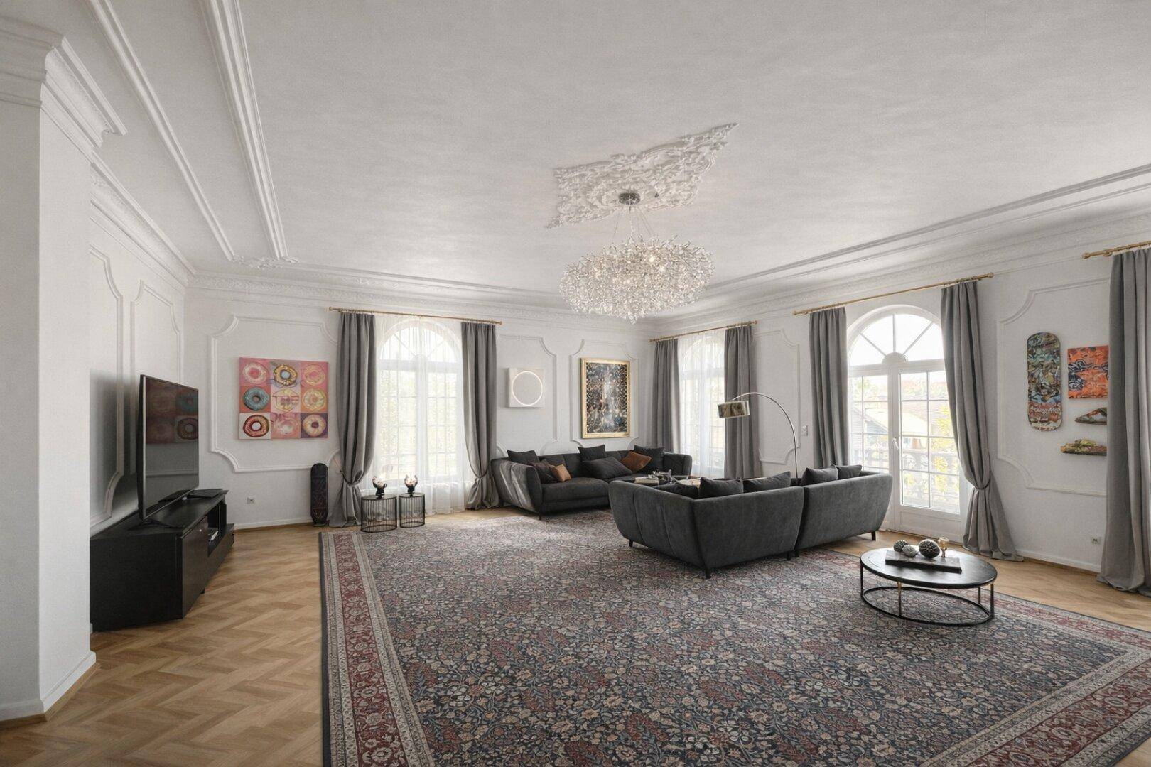 Großzügiges Wohnzimmer mit Fischgrätparkett, hohen Stuckdecken und moderner Dekoration.
