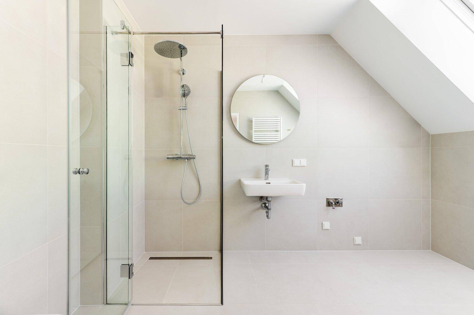 Elegantes Badezimmer mit begehbarer Dusche, Einzelwaschbecken und beheiztem Handtuchhalter unter einem Dachfenster.
